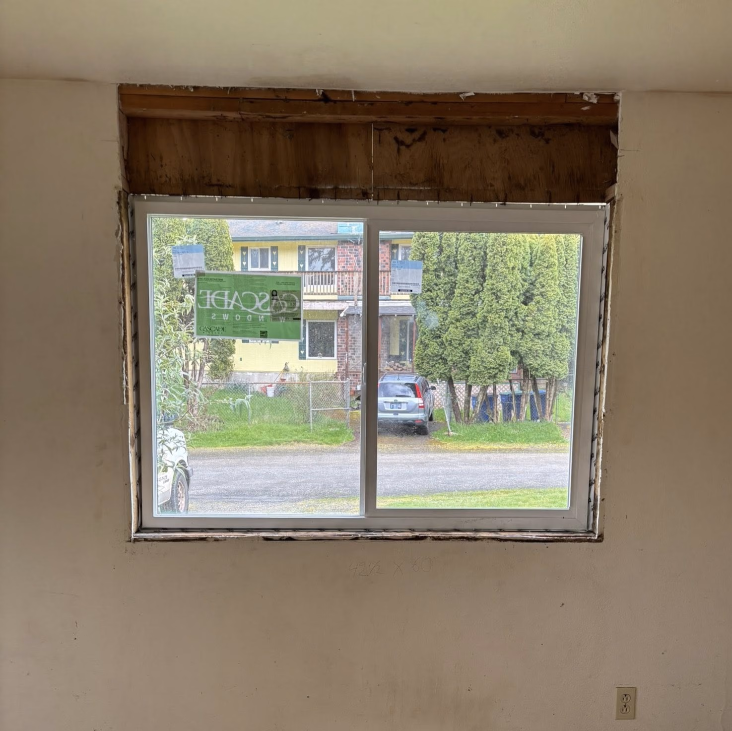 Newly installed sliding window without trim in an unfinished wall opening.